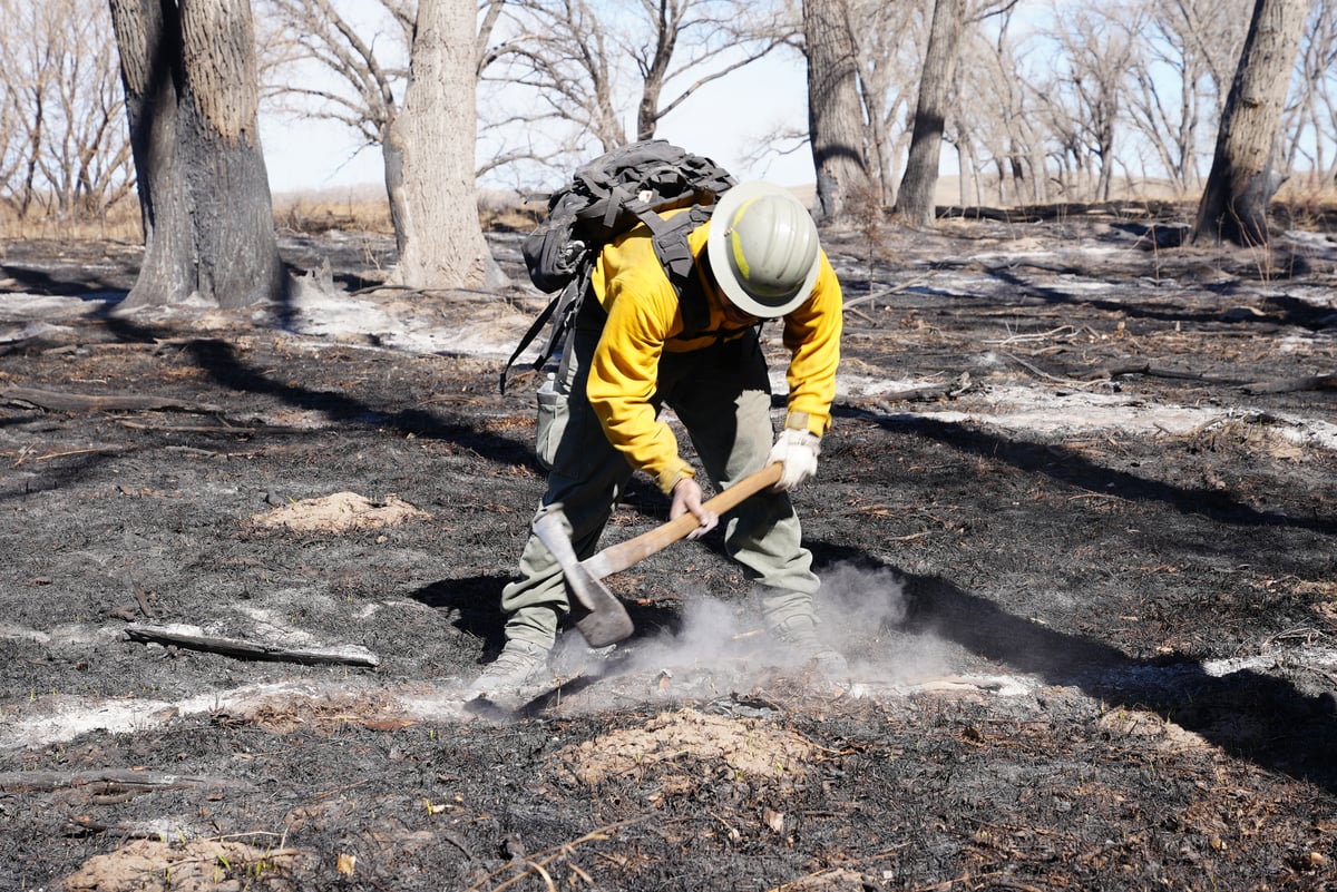 A Firefighter Digs to Extinguish a Hot Spot