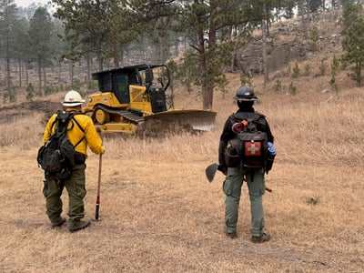 Firefighters use dozer line for structure protection.